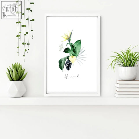 White framed botanical wall art with green leaves yellow flower and unwind script perfect for bathroom walls tropical oasis