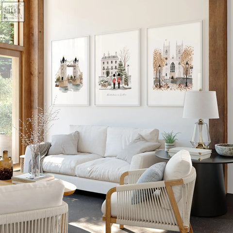 Three framed watercolor decorative wall hangings of london landmarks above a white sofa in a living room setting