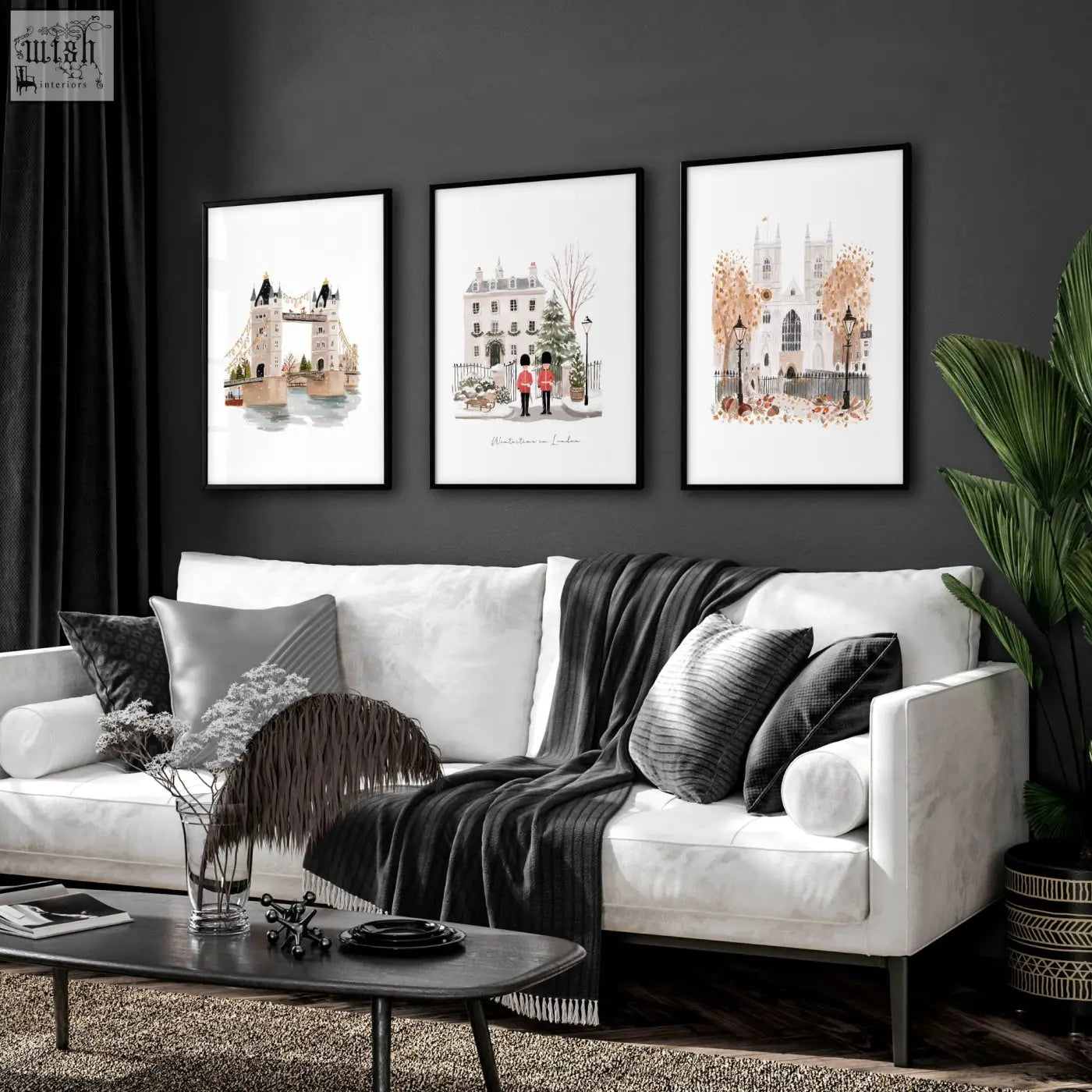 White sofa with black and gray throw pillows and dark gray blanket below decorative wall hangings wintertime in london