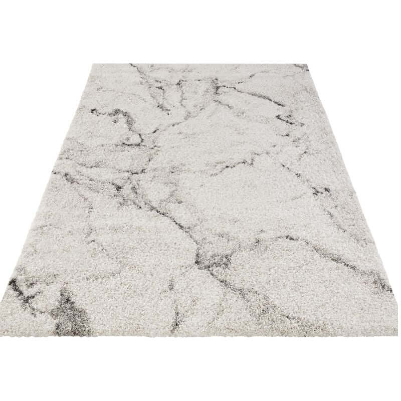 A plush deep-pile velour rug cream colour with shaggy texture and gray marble-like veining pattern