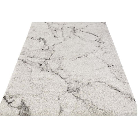 A plush deep-pile velour rug cream colour with shaggy texture and gray marble-like veining pattern