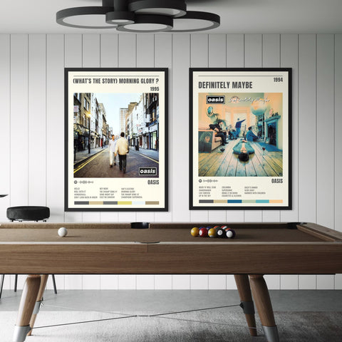 Two framed oasis album track posters for definitely maybe and whats the story morning glory above a wooden pool table