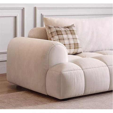 Cream-colored plush upholstered delilah violet two seater sofa with tufted cushions and plaid accent pillow