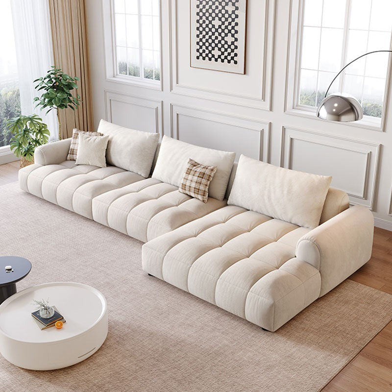 Cream-colored delilah violet two seater four seater sofa with tufted plush cushions and matching throw pillows