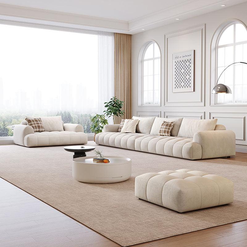 Cream-colored tufted fabric delilah violet two seater and four seater sofa with matching ottoman and round coffee table