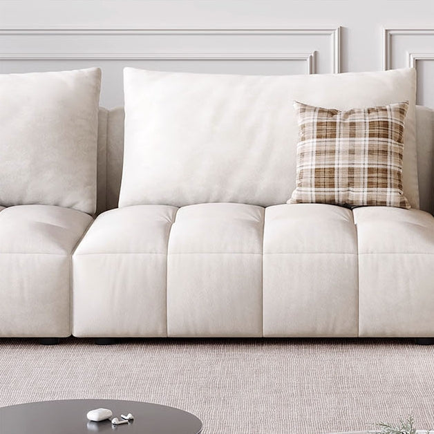 Cream-colored tufted delilah violet two seater sofa with plaid accent pillow and soft fabric upholstery