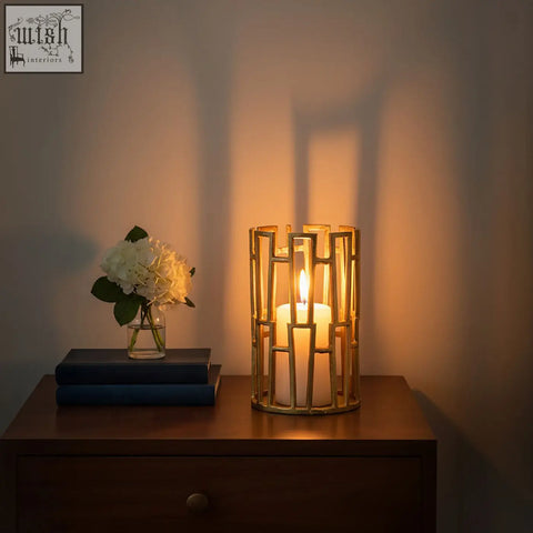 Gold-toned delphi aluminium candle holder with geometric design and white pillar candle inside