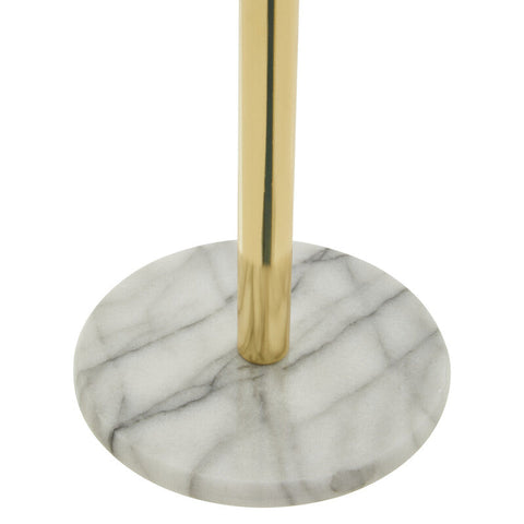 Delphine gold kitchen roll holder with gold-toned pole mounted on a white marble base with gray veining