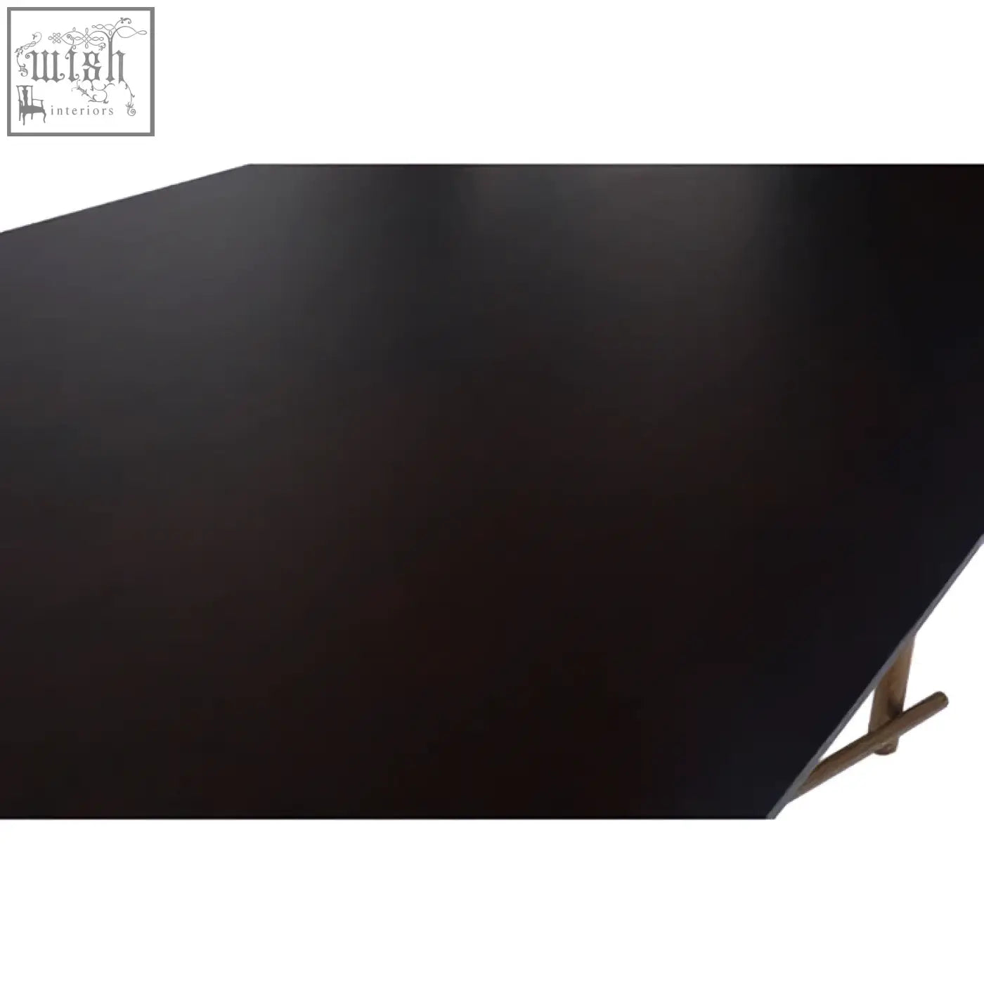 Black matte finish tabletop of delta walnut veneer dining table with sleek brass legs and minimalist design