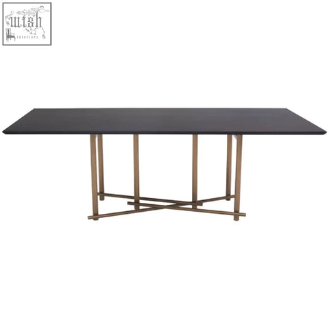Black delta walnut veneer dining table with a sleek design and brushed brass x-pattern legs for modern dining space