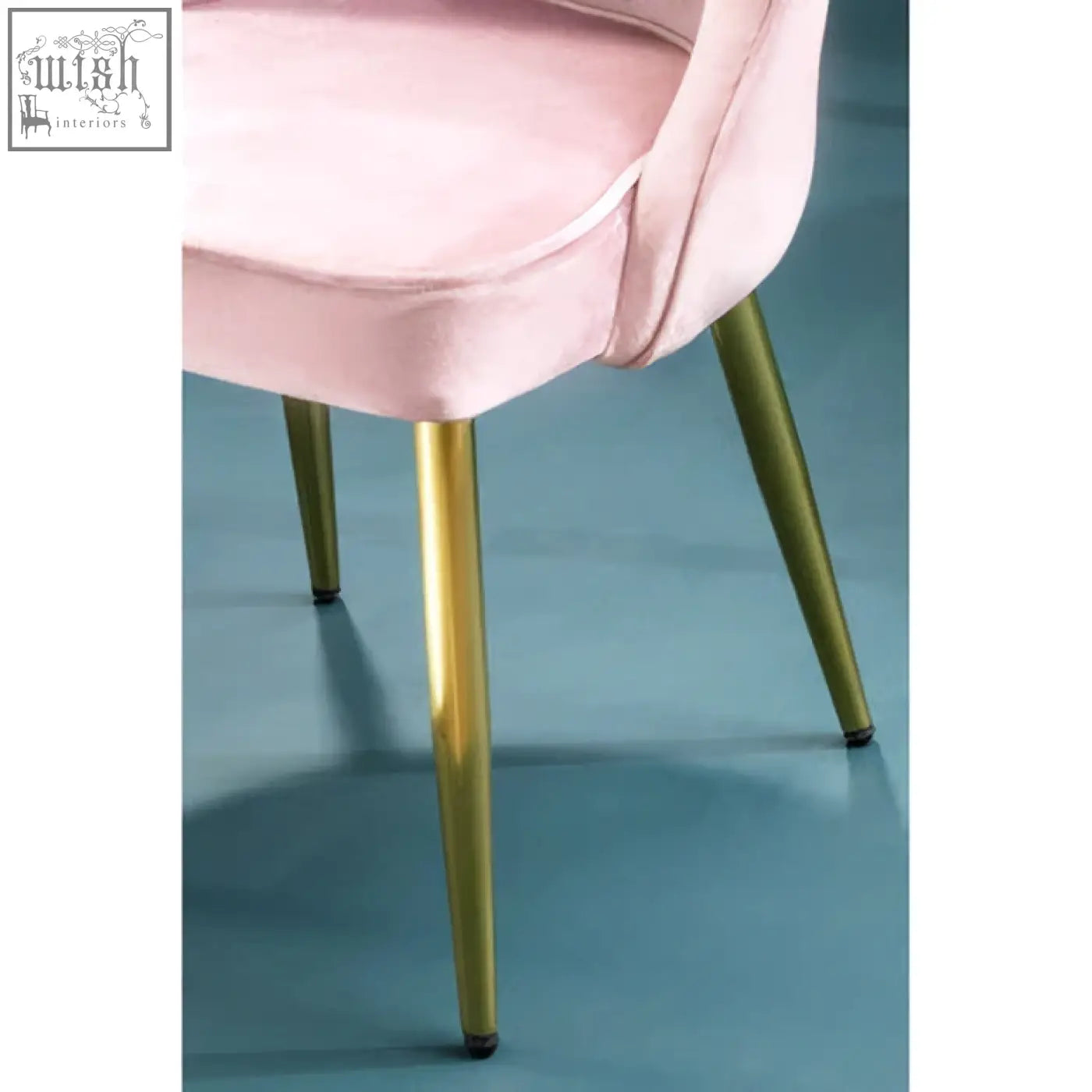 A demi dusky pink velvet dining chair with soft pink velvet upholstery and sleek gold metal legs