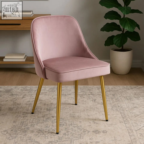 A soft pink velvet chair with slender gold metal legs perfect as a dusky pink velvet dining chair