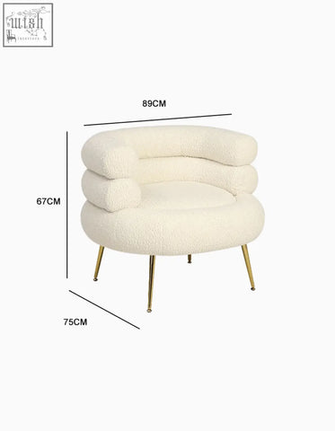 Demure boucle armchair in cream plush sheepskin with gold-tone legs adds art-deco glamour to any room
