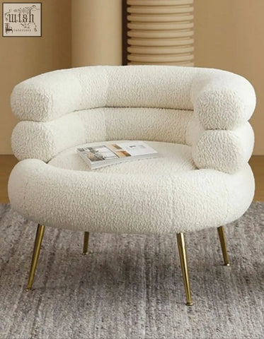 Cream-colored demure boucle armchair with plush sheepskin texture and gold-tone legs adds art-deco glamour to any space