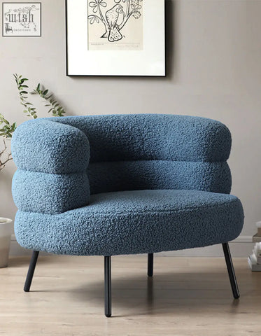 Demure boucle armchair in teal blue sheepskin style with rounded contours and black metal legs adds art-deco glamour