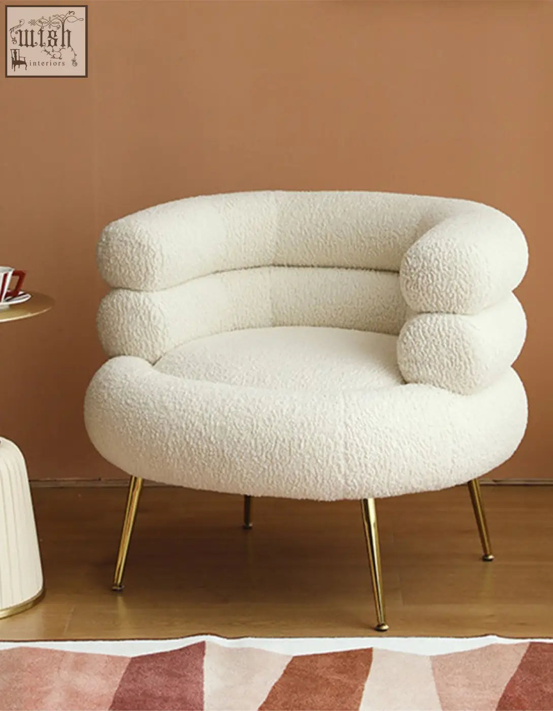 Cream-colored demure boucle armchair with plush sheepskin-like fabric and gold-tone legs adds art-deco glamour