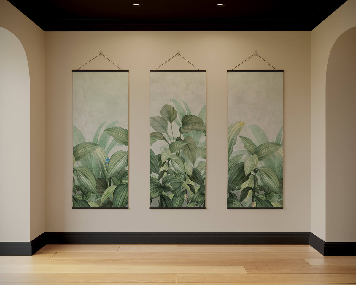 Three vertical dense jungle tapestries with lush green leaf patterns hanging on a beige wall as dense jungle wall decor