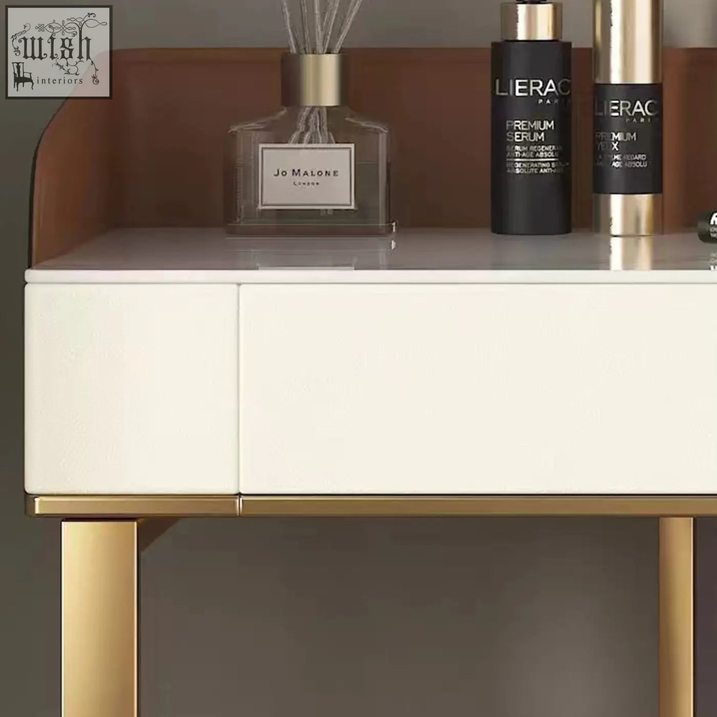 A sleek white denver dressing table with gold legs and mirror showcasing luxury skincare products and minimalist design