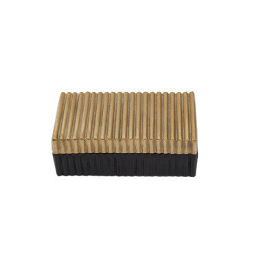 Small gold and black trinket box with a rectangular brass and black rubber eraser featuring vertical ridges