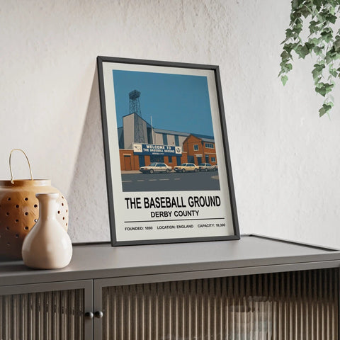 A framed derby county baseball ground print showing a stylized stadium with vintage cars under a blue sky