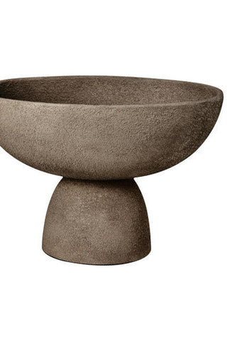 A sleek matte textured grey pedestal bowl made of stone with a minimalist design perfect for display or serving