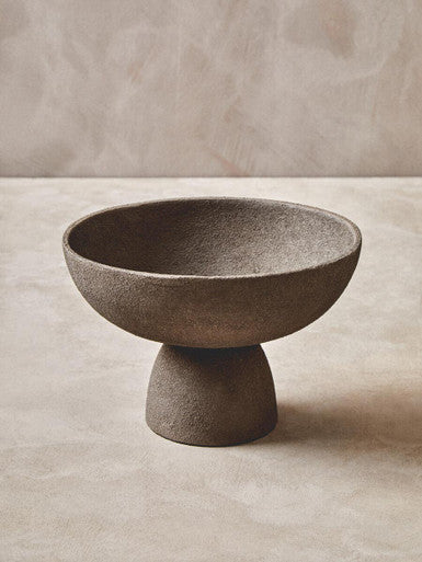 Gray textured ceramic pedestal bowl with a small base perfect for stylish serving or display in textured grey finish