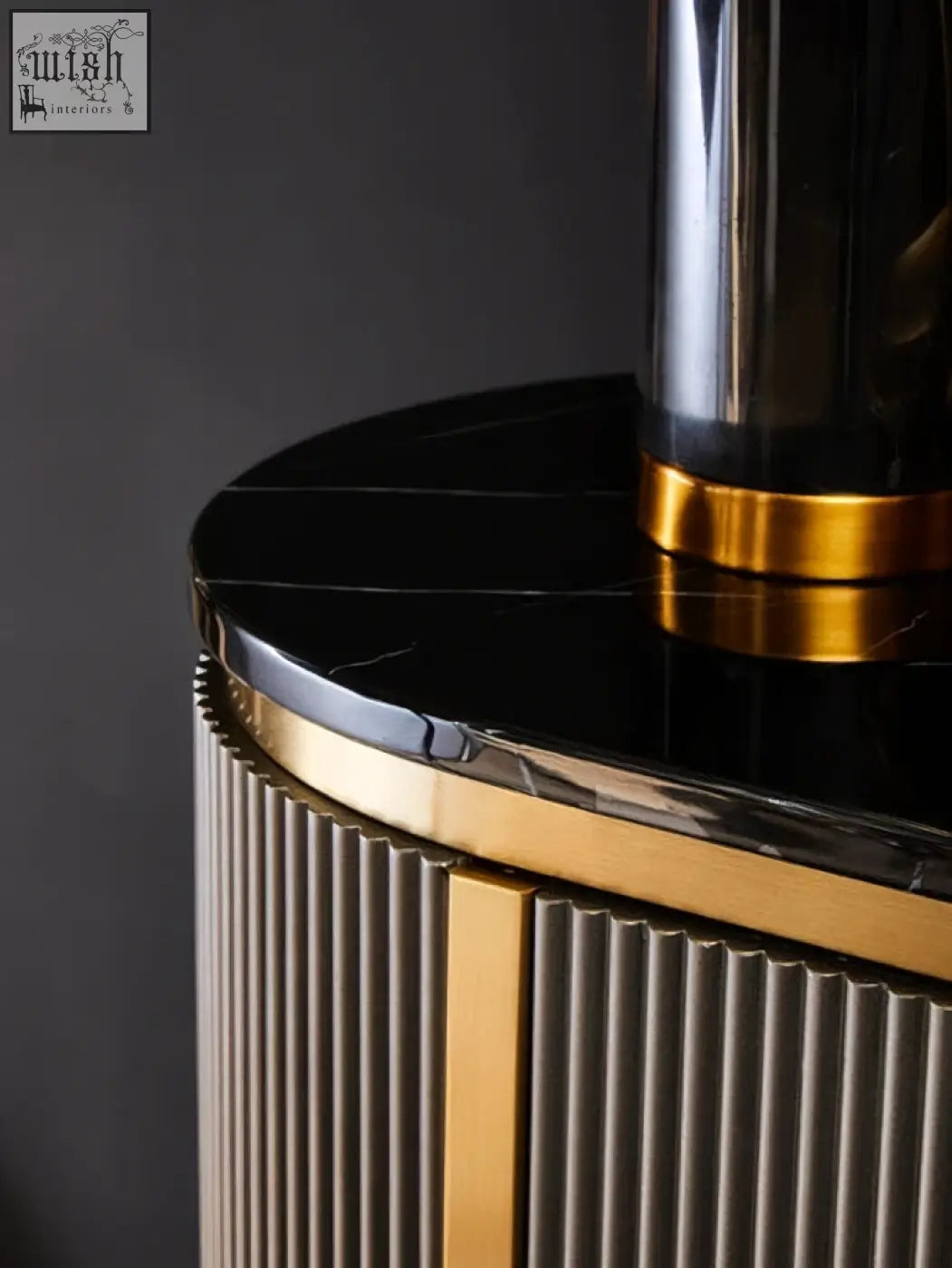 Black marble top grey four door sideboard with gold trimmed fluted sides in a sleek modern design