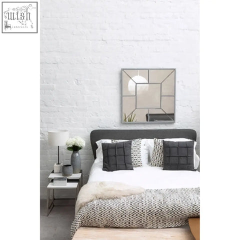 Large solar effect wall mirror with geometric mirrored panels and a silver-toned metallic frame