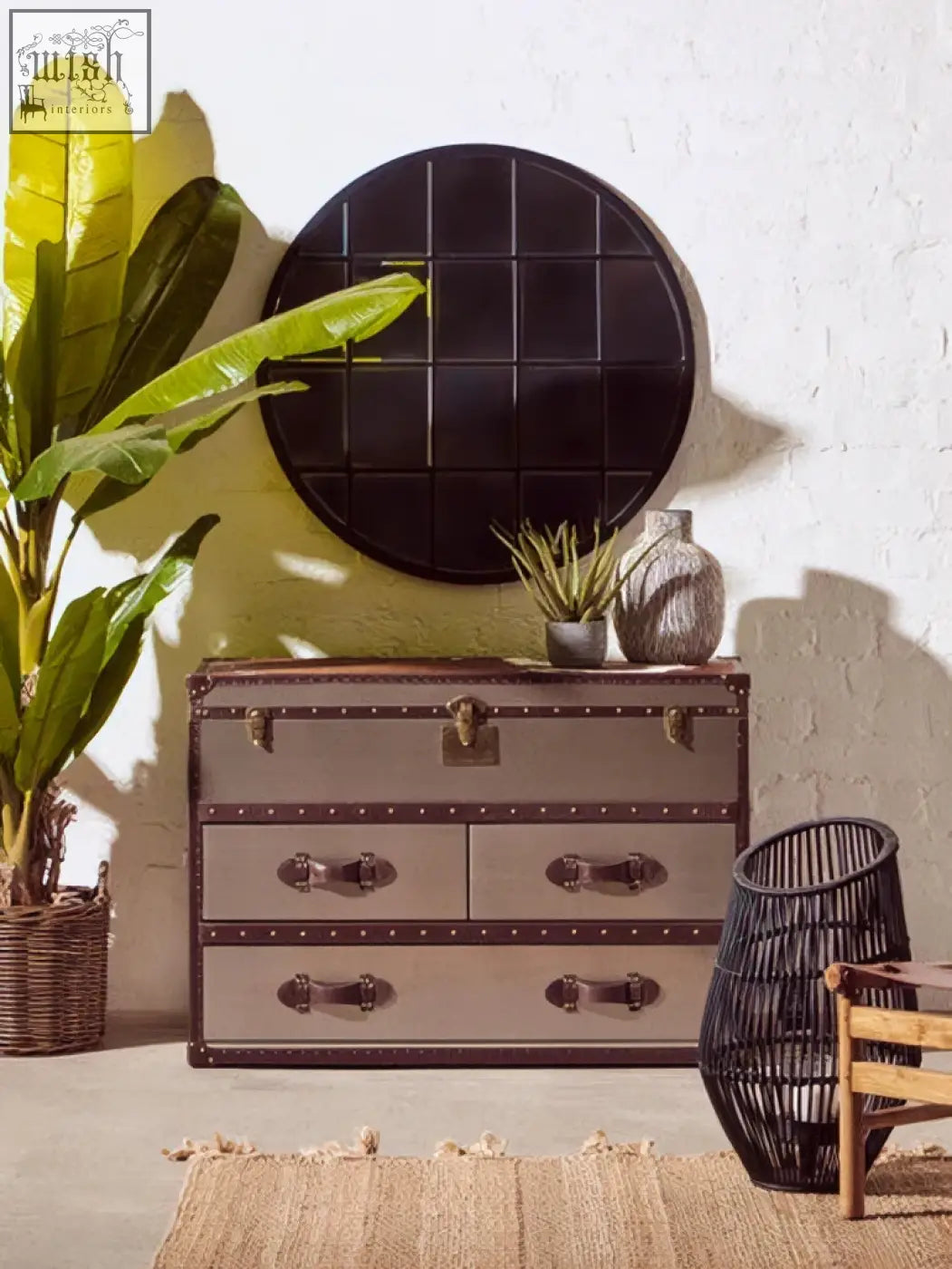 Vintage-style metallic trunk with leather accents and brass hardware perfect for storing accessories near descartes round metal wall mirror