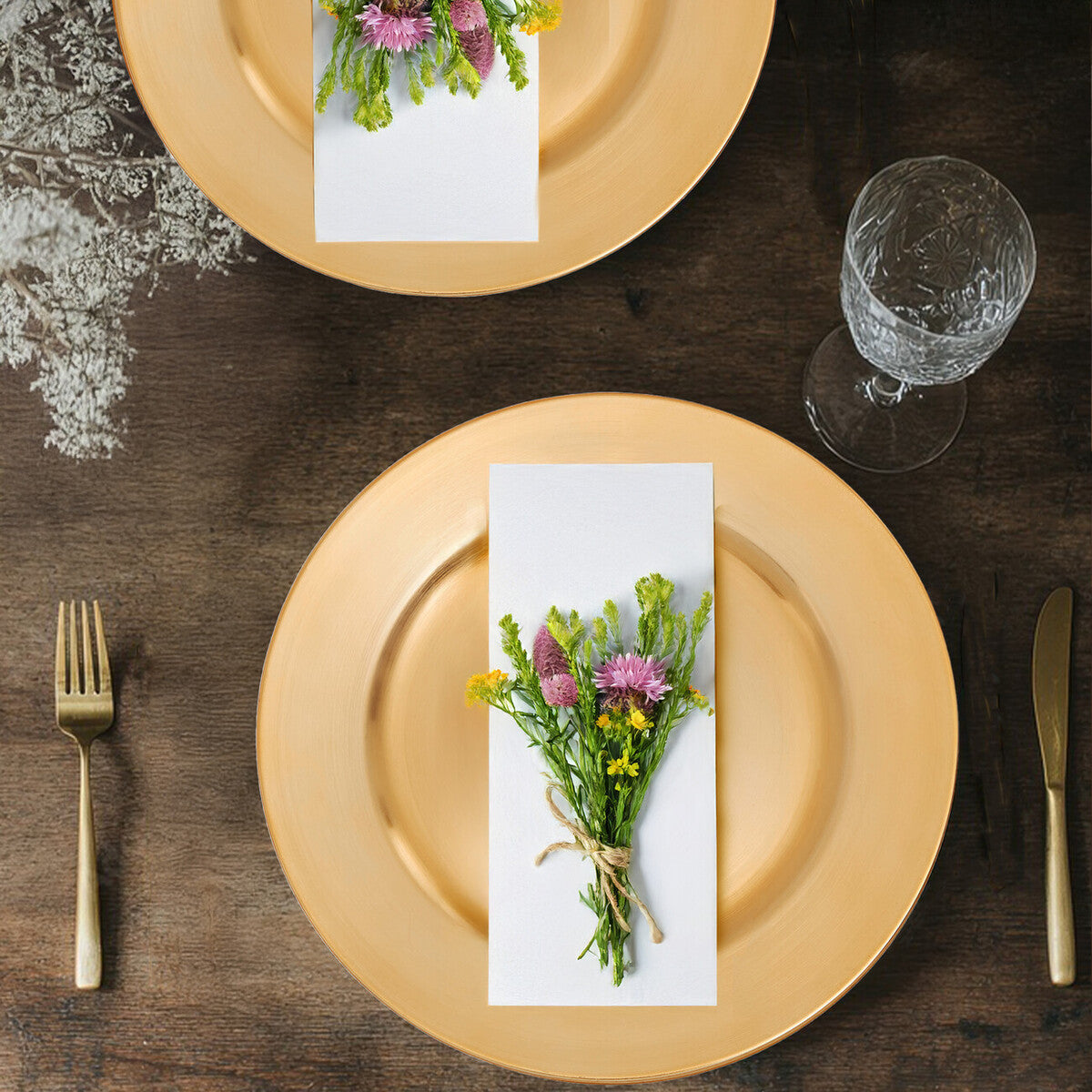 Dia gold finish charger plate with gold rim holding a white napkin and pink yellow wildflowers tied with twine