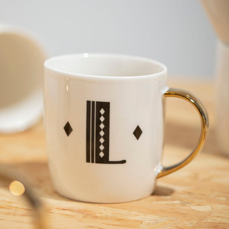 Diamond deco white monogram mug l with white ceramic body gold-toned handle and black geometric letter l design