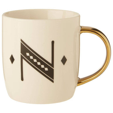 Cream-colored ceramic diamond deco white mug with gold handle and black geometric n design with diamond shapes