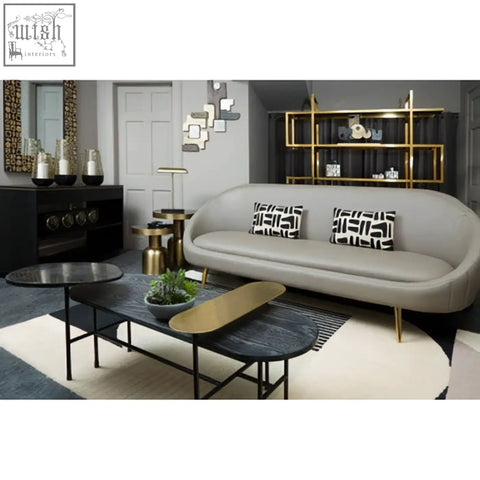 Modern gray sofa with gold legs and black and white pillows beside a diamond oak veneer console table with oak veneer finish
