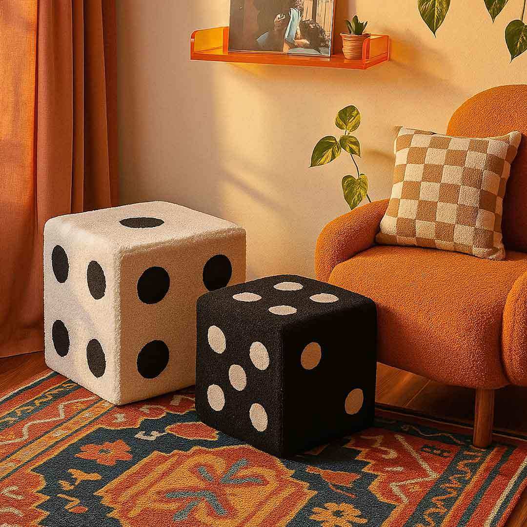 Two plush dice footstool in cream with black dots and black with white dots on a patterned rug by orange armchair 22cm x 22cm and 33cm x 33cm
