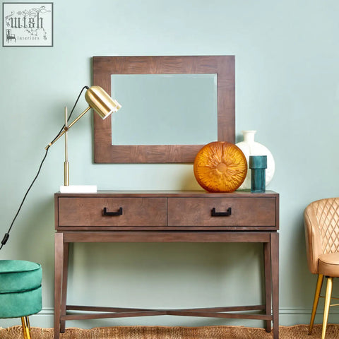 Brown wooden console table with two drawers and black handles complementing the antique grey wall mirror