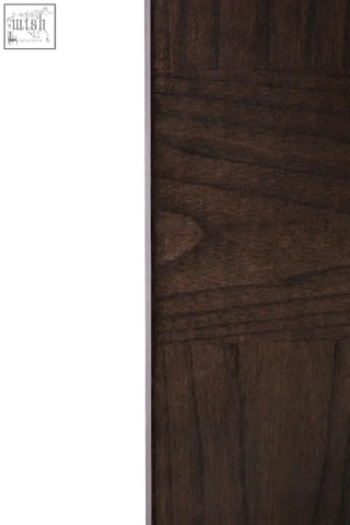 Dark brown wooden door with textured grainy surface and horizontal paneling beside antique grey wall mirror