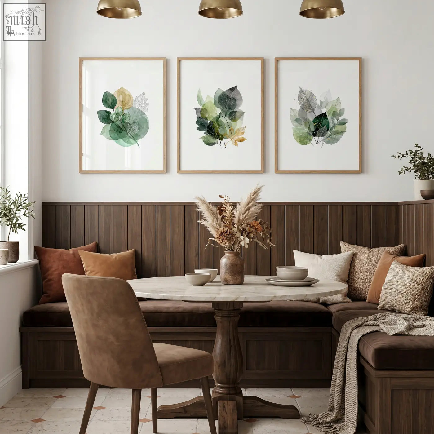 Round marble-top dining room table with dark wood pedestal base shown with green and gold-toned dining room art wall prints