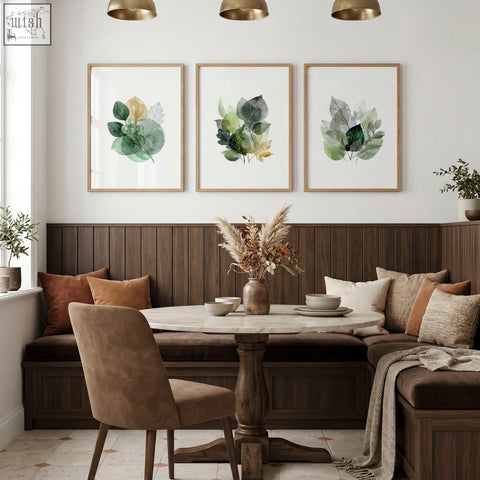 Round marble-top dining room table with dark wood pedestal base shown with green and gold-toned dining room art wall prints