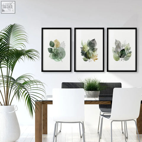 Three framed botanical wall art prints with muted green and gold leaves in black frames perfect for dining room art