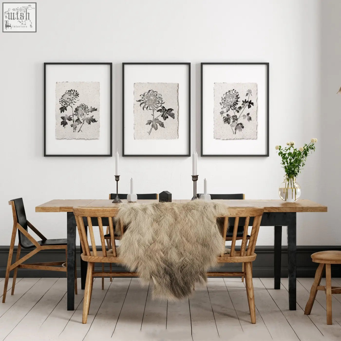 Three black-framed botanical chrysanthemum ink study wall art prints hang above a wooden dining room table