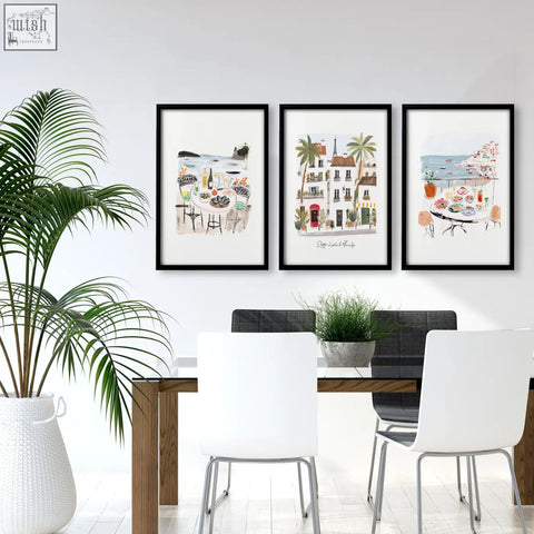 Three black framed watercolor prints showing seaside dining and european architecture for dining room wall art