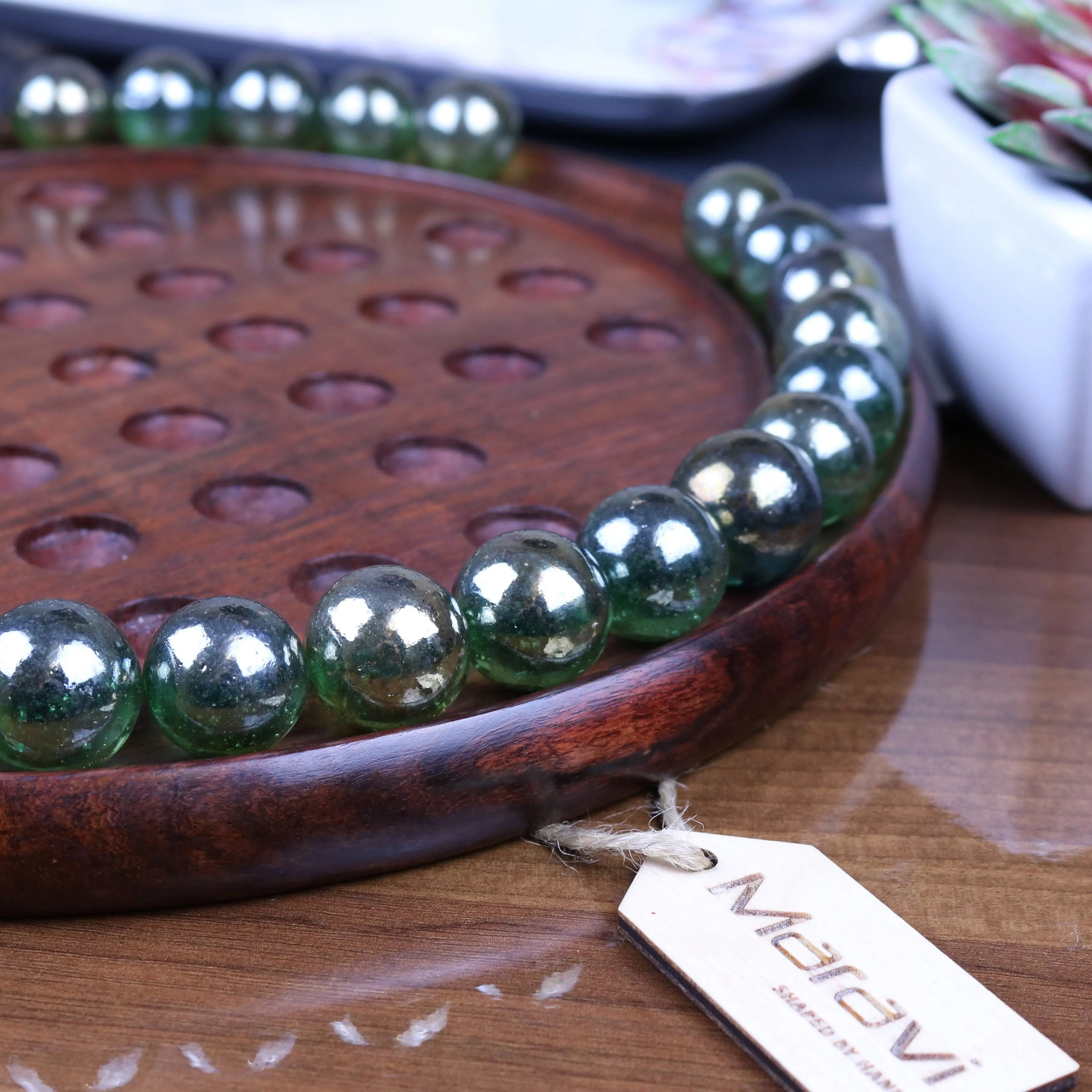 A dinod large wooden solitaire game set with glossy translucent green glass beads arranged in a circular pattern
