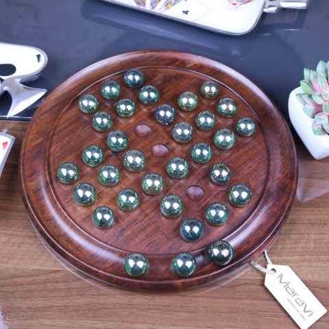 Dinod large wooden solitaire game set with round board and polished green and silver marbles arranged in pattern