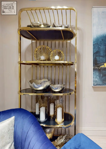 Gold-toned metal shelving unit with black glass shelves and dion large ombre silver and gold finish candle holder displayed