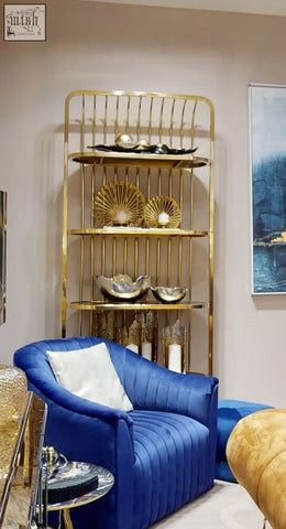 Blue velvet armchair with tufted upholstery and white cushion next to dion large ombre silver and gold finish candle holder