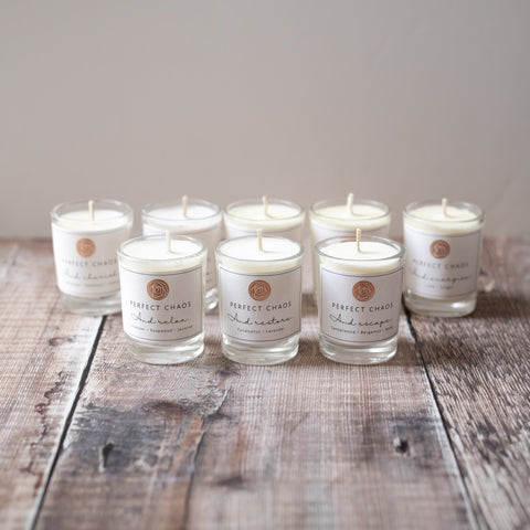 Set of six clear glass votive candles with white wax and minimalist perfect chaos labels in discovery set
