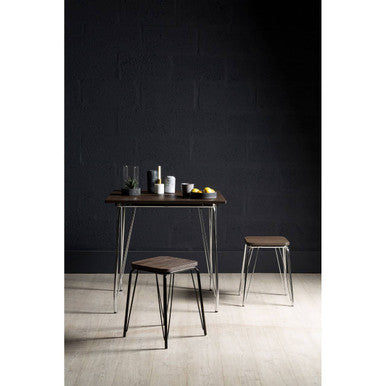 Minimalist district chrome metal and elm wood table with black top and slender legs, paired with two matching stools