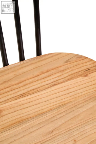 Light-colored elm wood seat dining chair with black vertical spindles and metal frame for stylish dining rooms