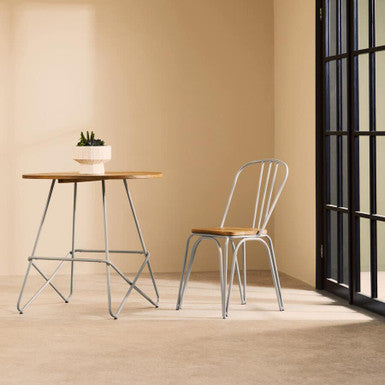 Minimalist district grey metal dining table with elm wood round top and slender geometric legs for modern spaces
