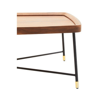 A sleek wooden doha coffee table with curved edges and black cross metal legs capped in gold for stylish living rooms